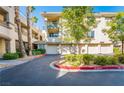 Condominium building showing attached garages, landscaping, and mature palm trees at 7189 S Durango Dr # 203, Las Vegas, NV 89113
