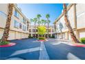 Condominium building showing attached garages, beautiful landscaping, and mature palm trees at 7189 S Durango Dr # 203, Las Vegas, NV 89113