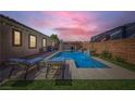Relaxing backyard featuring a private pool with sun loungers, a waterfall feature, and lush landscaping at 7418 Lawrence Powers Ct, Las Vegas, NV 89129