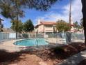 Community pool is fenced and includes a water access ladder, and is surrounded by trees and common-area landscaping at 809 Rock Springs Dr # 202, Las Vegas, NV 89128