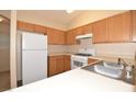 Functional kitchen featuring wood cabinetry and white appliances, with plenty of room for cooking at 8842 Duncan Barrel Ave # 101, Las Vegas, NV 89178