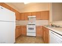 Well-lit kitchen boasts wood cabinets, white appliances, and ample counter space for meal preparation at 8842 Duncan Barrel Ave # 101, Las Vegas, NV 89178