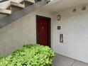 Outdoor entrance to condo unit with fire extinguisher and green shrubbery at 950 Seven Hills Dr # 114, Henderson, NV 89052