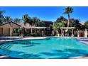Inviting community pool with shade structure surrounded by lounge chairs and mature landscaping at 950 Seven Hills Dr # 114, Henderson, NV 89052