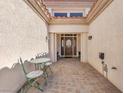 Charming courtyard entrance with a decorative patio set and covered walkway to the front door at 9916 Netherton Dr, Las Vegas, NV 89134