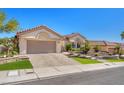 Charming single-story home with a tile roof, two-car garage, and lush desert landscaping at 9916 Netherton Dr, Las Vegas, NV 89134