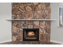 Close up of the living rooms unique stone fireplace with a rustic mantle at 1112 Observation Dr # 201, Las Vegas, NV 89128