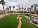 This lush backyard features a large lawn, palm trees, pool, and waterfall; perfect for outdoor living and entertaining at 1407 Fields St, Las Vegas, NV 89142
