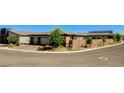 Wide angle view of this single-story home featuring a three-car garage and landscaped front yard at 21 Reverie Heights Ave, Henderson, NV 89011
