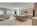 Open kitchen with a large island, counter seating, stainless appliances, and a seamless flow to living spaces at 21 Reverie Heights Ave, Henderson, NV 89011