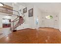 Spacious living room boasting hardwood floors, high ceilings, a staircase, and a modern light fixture at 2112 Preakness Pass, Las Vegas, NV 89117