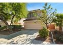 Inviting two-story home featuring a two-car garage, complemented by mature trees and lush landscaping at 2333 Silver Crew Pass, Henderson, NV 89052