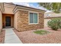 Close up showing a single-story home's exterior featuring stone accents, a dark front door, and low-maintenance landscaping at 2343 Galilean Moon St, Henderson, NV 89044