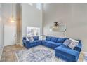 Bright living room boasts soaring ceilings, a large comfortable sofa, and neutral tile flooring at 2496 Citrus Garden Cir, Henderson, NV 89052