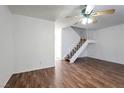 Bright living room featuring laminate floors, ceiling fan, and staircase at 3164 Richford Pl, Las Vegas, NV 89102