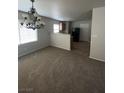 Spacious living room with carpeted floors, leading into the kitchen area at 3748 Autumn King Ave, Henderson, NV 89052