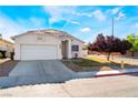 Attractive single-story home with a two-car garage, desert landscaping and a beautiful shade tree at 3839 Dusty Glen Ct, North Las Vegas, NV 89032