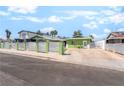 Green home with a white horizontal slat fence surrounding the property and a well-maintained concrete driveway at 4406 Parkchester Cir, Las Vegas, NV 89108