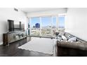 Bright living room features a leather sofa, sleek TV console, and expansive city views at 4471 Dean Martin Dr # 1502, Las Vegas, NV 89103