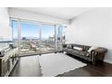 Bright living room features a leather sofa, sleek TV console, and expansive city views at 4471 Dean Martin Dr # 1502, Las Vegas, NV 89103
