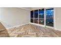 Bright living room featuring herringbone-patterned floors, large windows, and a city view at night at 4575 Dean Martin Dr # 2701, Las Vegas, NV 89103