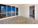 Inviting living room showcasing herringbone-patterned floors, a balcony, and stunning city views at 4575 Dean Martin Dr # 2701, Las Vegas, NV 89103