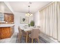 Cozy dining area with a modern chandelier, table set for six, and lots of natural light at 4614 Grand Dr # 1, Las Vegas, NV 89169