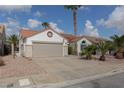 Street view of single-story home featuring a two-car garage, desert landscaping, and a classic terra cotta roof at 517 Scenic Terra Dr, Henderson, NV 89015