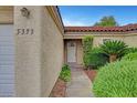 Inviting front entrance with a white door, stylish address numbers, and manicured bushes at 5373 Painted Mirage Rd, Las Vegas, NV 89149
