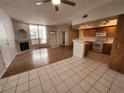 Open-concept living room and kitchen featuring tile and wood flooring with a gas fireplace and natural light at 6908 Dorita Ave # 101, Las Vegas, NV 89108
