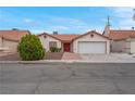 Well-kept single-story home with a red door, two-car garage, and desert landscaping at 8024 Hackberry Dr, Las Vegas, NV 89123