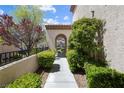 Inviting front walkway with mature landscaping leading to an arched entryway at 820 Colina Alta Pl, Las Vegas, NV 89138