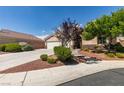 Charming single story home with a two car garage, desert landscaping, and tile roof under sunny blue skies at 8204 Turbys Treehouse Pl, Las Vegas, NV 89131