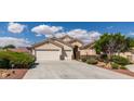 Charming single story home with a three car garage, desert landscaping, and a tile roof under sunny blue skies at 8204 Turbys Treehouse Pl, Las Vegas, NV 89131