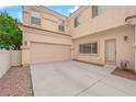 Attached two-car garage with large concrete driveway and outdoor access door at 8873 Happy Stream Ave, Las Vegas, NV 89143
