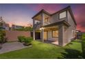 The backyard has a cozy patio, green turf, and a putting green for entertainment and relaxation at 10793 Pastel Sunset Ct, Las Vegas, NV 89135