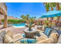 Relaxing patio with seating, surrounded by lush landscaping and a beautiful pool at 11219 Playa Bonita Ave, Las Vegas, NV 89138