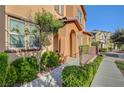 Exterior of the residence featuring a covered entryway, windows, and green landscaping at 11420 Ogden Mills Dr # 101, Las Vegas, NV 89135