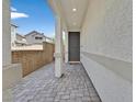 Inviting entryway features a paved walkway, covered porch with decorative columns, and a gray front door at 117 Destiny Orchard Ct, Henderson, NV 89011