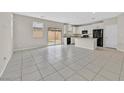 Spacious living room featuring tile flooring, with views of the open kitchen and sliding glass doors at 117 Destiny Orchard Ct, Henderson, NV 89011
