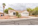 Charming single-story home with a red tile roof, desert landscaping, and an attached two-car garage at 1220 Basin Brook Dr, North Las Vegas, NV 89032