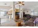 Inviting living room that opens to the kitchen, with a ceiling fan and comfortable furnishings at 1220 Basin Brook Dr, North Las Vegas, NV 89032