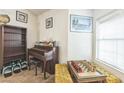 Cozy living area featuring a piano, chessboard, and natural light from a bright window with blinds at 1220 Basin Brook Dr, North Las Vegas, NV 89032