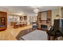 Open-concept living room featuring a brick fireplace, hardwood floors, and seamless flow to the kitchen at 1700 Red Rock St, Las Vegas, NV 89146