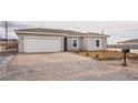 Charming single-story home with a two-car garage and desert landscaping at 2071 Idaho St, Pahrump, NV 89048