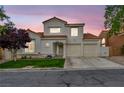 Charming two-story home features a terracotta roof, stucco facade, and a well-manicured front yard at dusk at 2124 Rising Mist St, Las Vegas, NV 89134