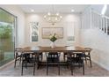 Bright dining room with tile floors, modern lighting, and a stylish table set for elegant dinners at 3218 Mura Del Prato Ave, Henderson, NV 89044
