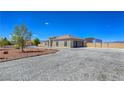 Wide driveway leading to a stucco home with an attached garage and additional metal building at 3780 Shawnee Ave, Pahrump, NV 89048