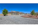 Tan stucco home with symmetrical facade, large arched windows, and a circular driveway at 3780 Shawnee Ave, Pahrump, NV 89048