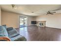 Open living room featuring a fireplace, sliding door to backyard, and vinyl flooring at 403 Woodridge Dr, Henderson, NV 89015